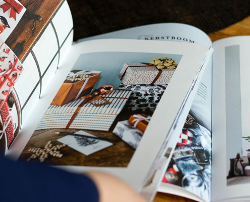 Person browsing Christmas catalogue