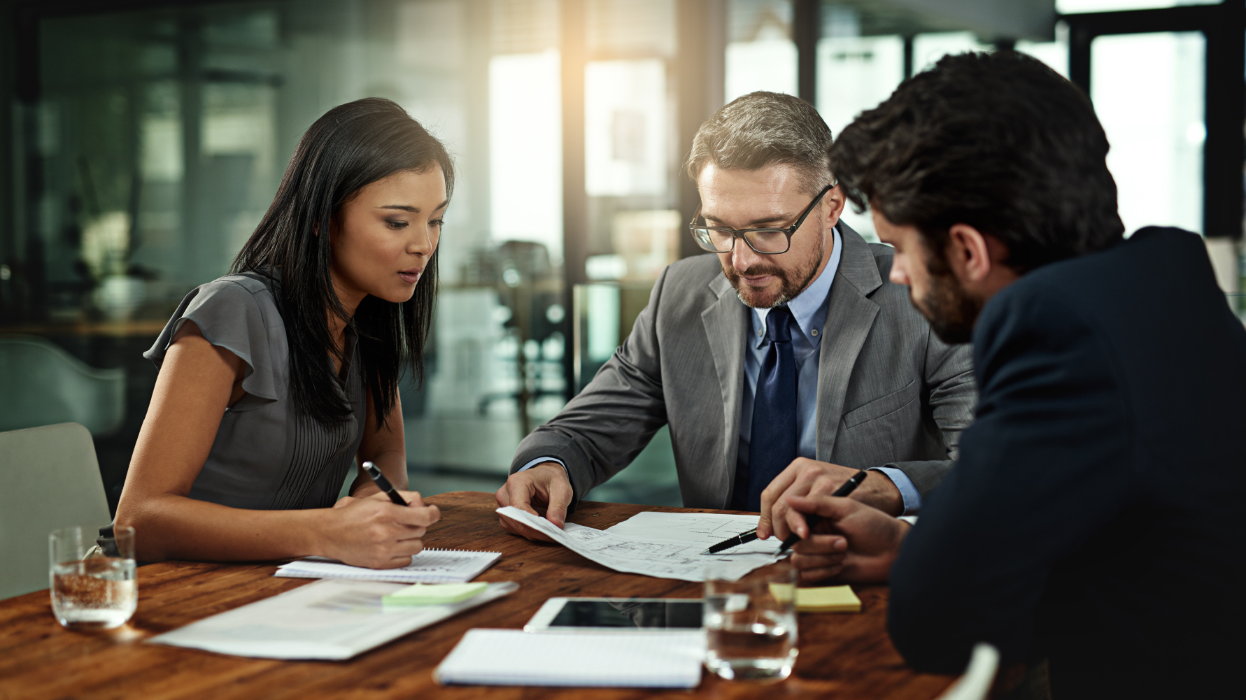 Business people sitting around a table looking at documents